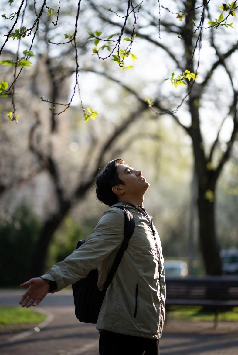 Чоловік навесні на вулиці насолоджується сонячним світлом під час сезонних змін в організмі після зимового періоду