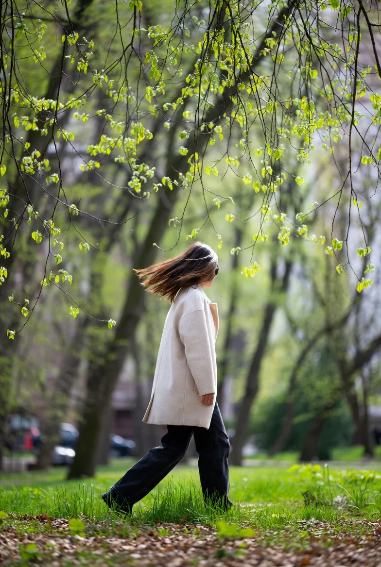 Дівчина прогулюється парком навесні, отримує денне світло для нормалізації сну