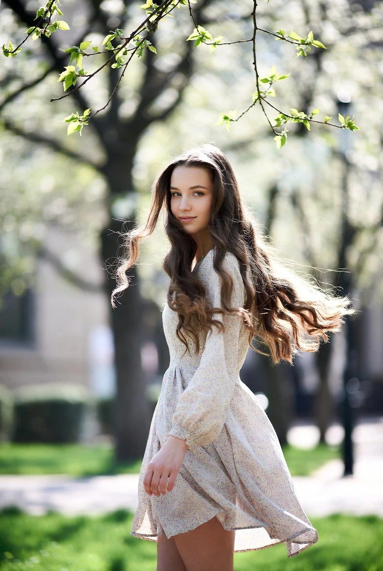 Дівчина у легкій сукні навесні на свіжому повітрі, гарне самопочуття